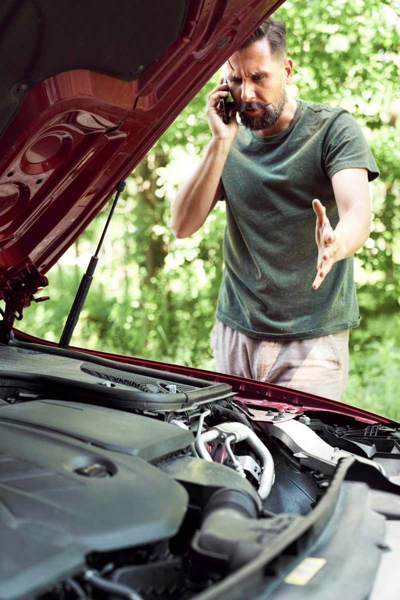 Junger Mann prüft Getriebeschaden bei Schrottauto Ankauf Hagen